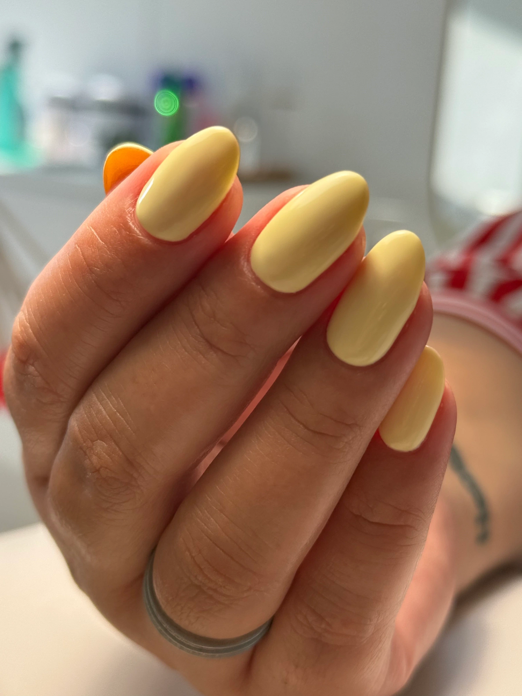 Unhas arredondadas em amarelo pastel.